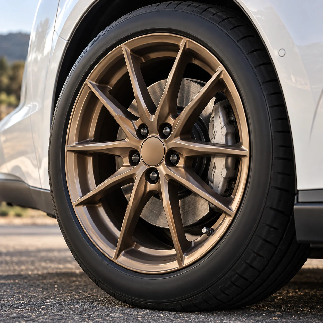 Illustrative close-up of a satin bronze forged multi-spoke wheel on a white electric crossover